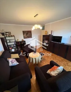 Living room with seating furniture, bookshelves, and a television. - image 4