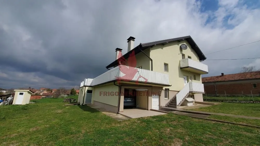 Pogled na spoljašnjost kuće sa dvorištem i garažom.