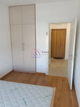 Spavaća soba sa krevetom, ugradnim ormarom i pogledom na ulazna vrata. - image 7