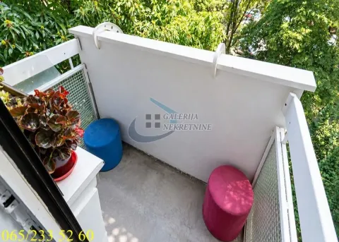 Smaller balcony with a white railing and colourful stools. - image 10