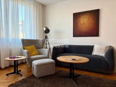 Living room with a sofa, armchair, coffee table, and an artwork on the wall. - image 6