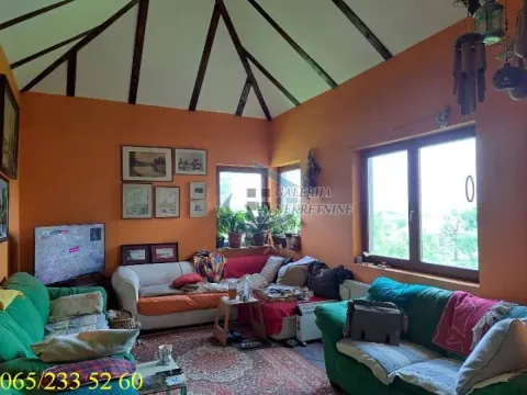 Dnevna soba sa garniturom za sedenje, televizorom i kosim plafonom sa drvenim gredama. - image 2