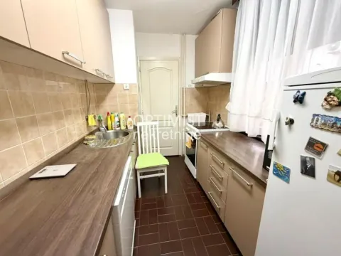 Manja kuhinja sa drvenim elementima, sudoperom i šporetom. - image 4