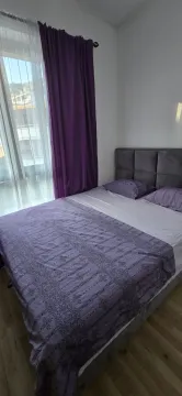 Bedroom with a double bed and purple curtains. - image 5