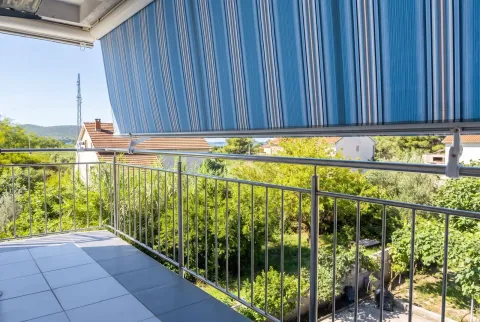 Natkriveni balkon sa metalnom ogradom i pogledom na prirodu i kućice. - image 19
