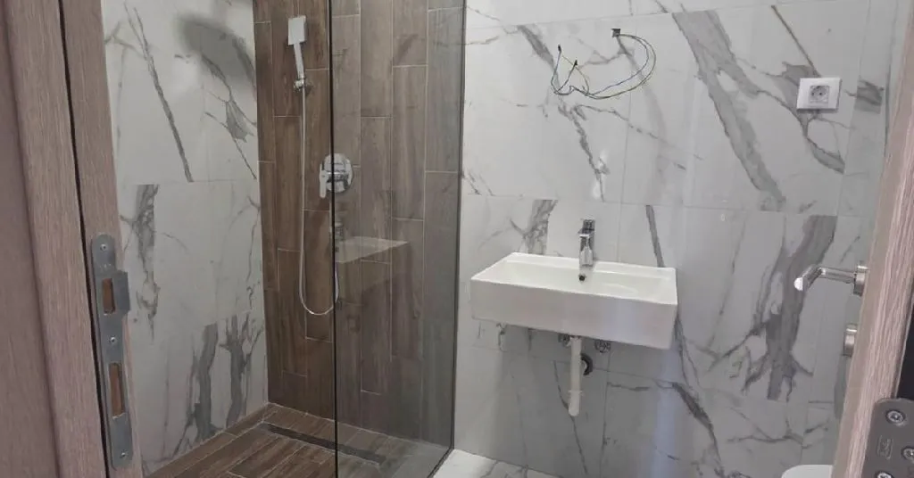 Novoopremljeno kupatilo sa tuš kabinom i umivaonikom.