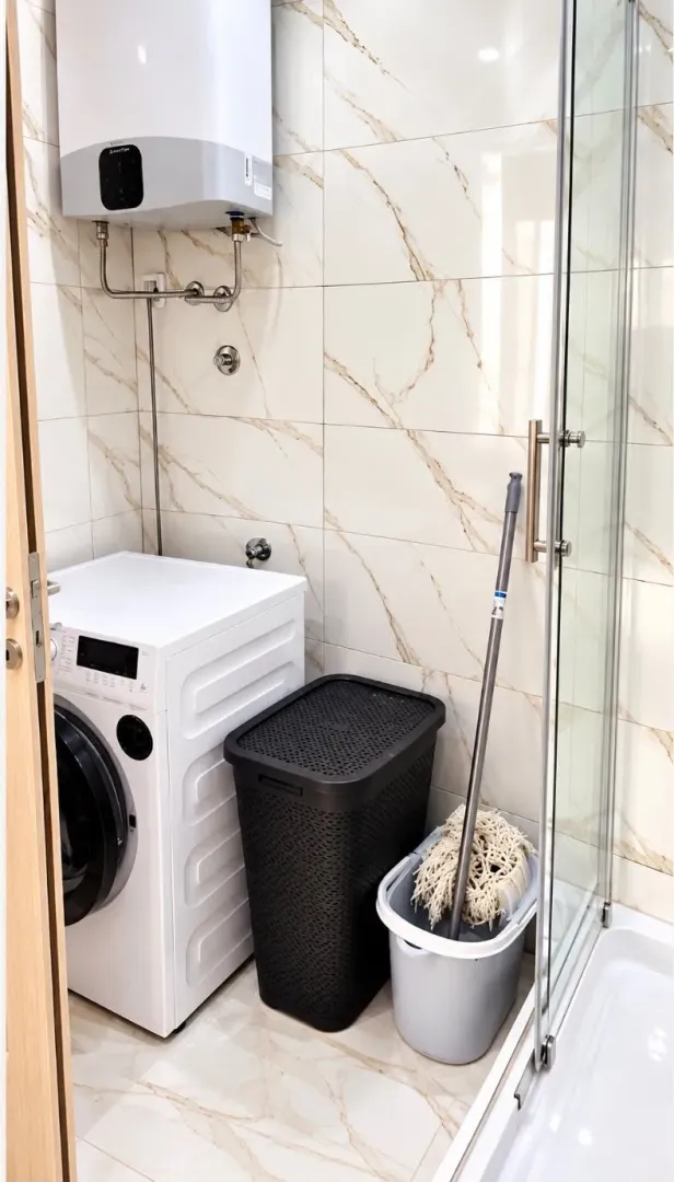 Bathroom equipped with a shower cabin, washing machine, and water heater.