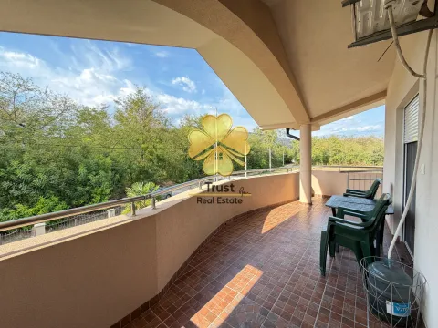 Spacious covered terrace with patio furniture and a green view. - image 11