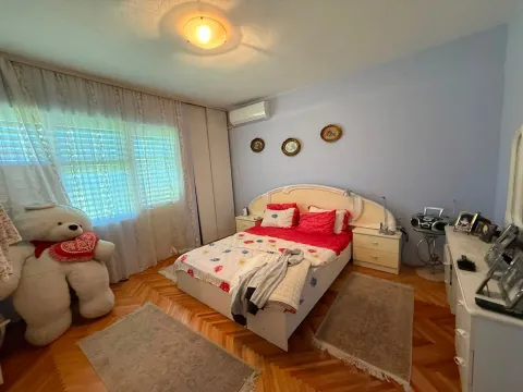 Furnished bedroom with a double bed, white wardrobe, and a large teddy bear. - image 11