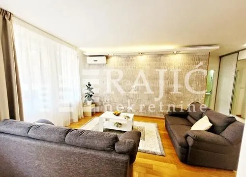 Spacious living room with a sofa and a decorative wall.