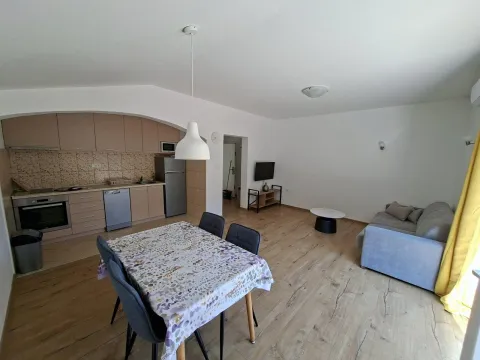 Open-plan living room with dining area and kitchen. - image 2