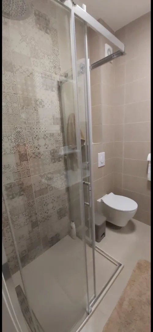 Savremeno opremljeno kupatilo sa tuš kabinom i wc šoljom.
