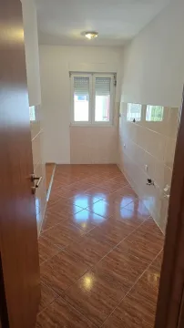 Prazna kuhinja sa pločicama na podu i zidovima. - image 6