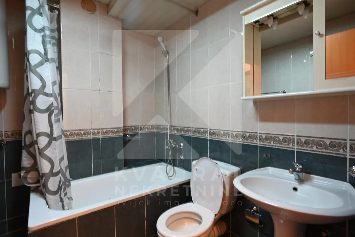 Bathroom equipped with a bathtub, washbasin, toilet, and a mirror.