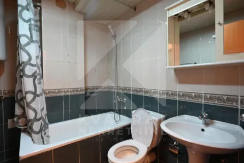 Bathroom equipped with a bathtub, washbasin, toilet, and a mirror. - image 10