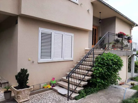 Vanjske stepenice koje vode do ulaza u kuću sa uređenom fasadom. - image 6