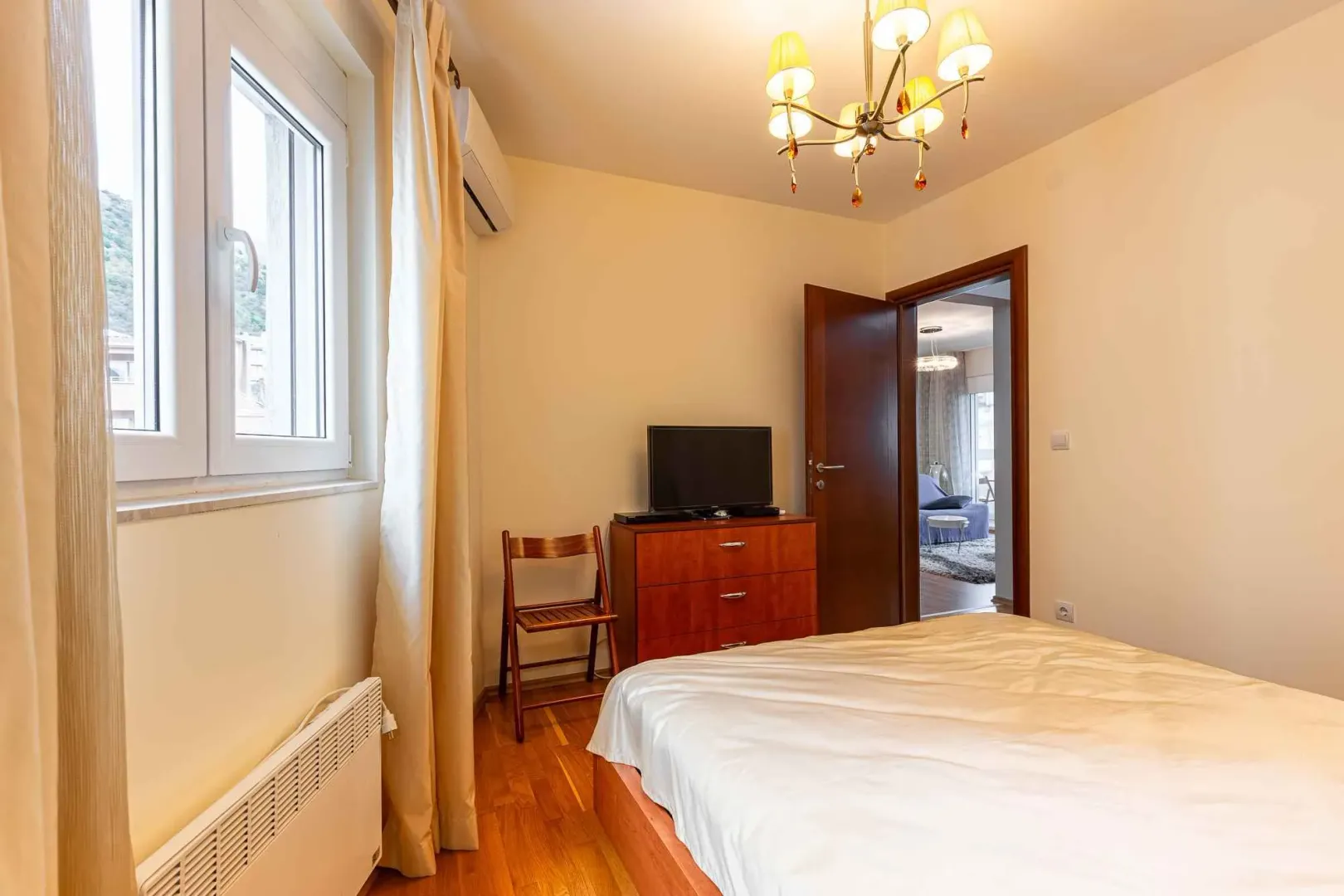 Bedroom with a double bed, chest of drawers, and television.