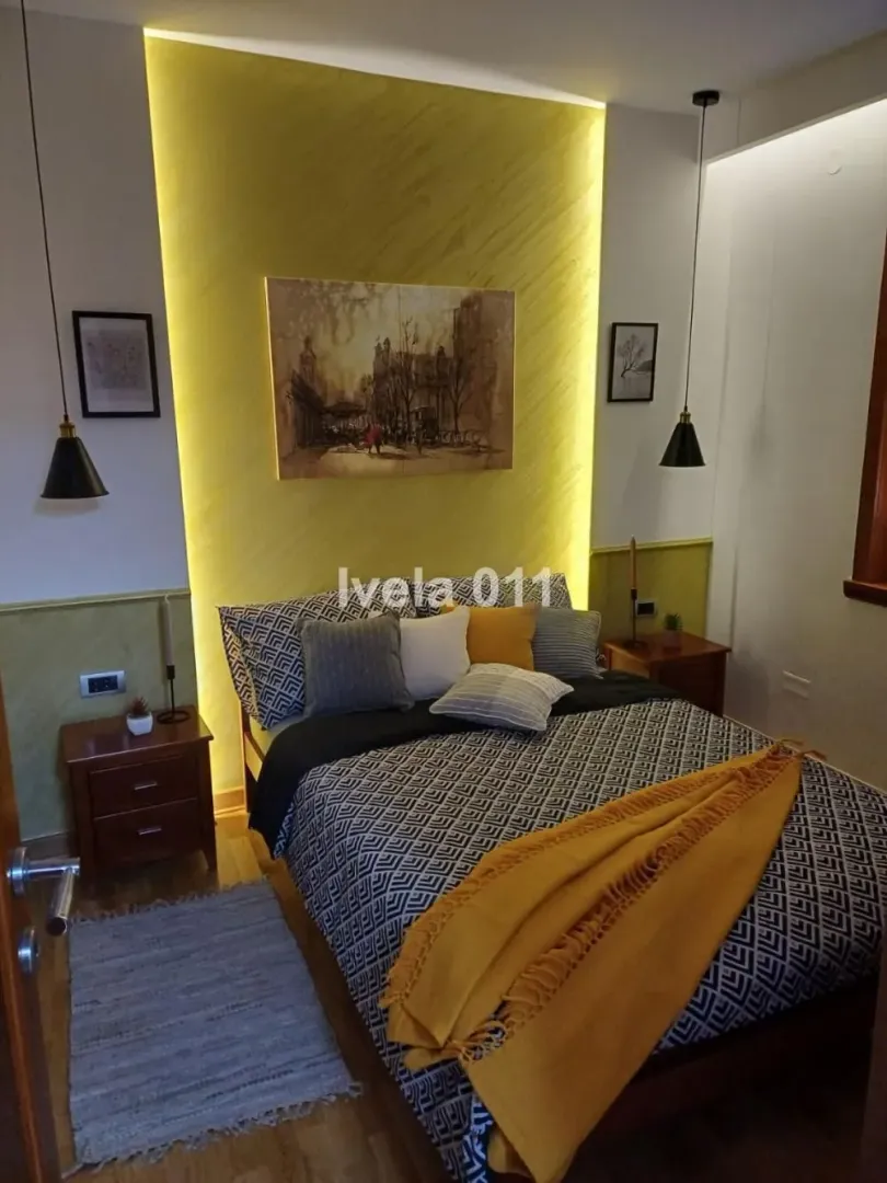 Modern bedroom with a double bed, decorative lighting and bedside tables.