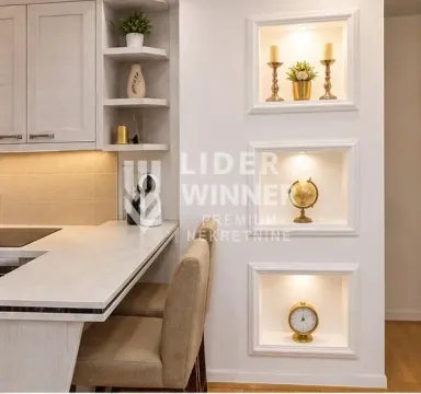 Part of the kitchen with a breakfast bar, chairs, and decorative built-in wall niches. - image 9