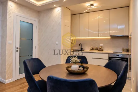 Modern kitchen with a dining table and blue chairs. - image 4