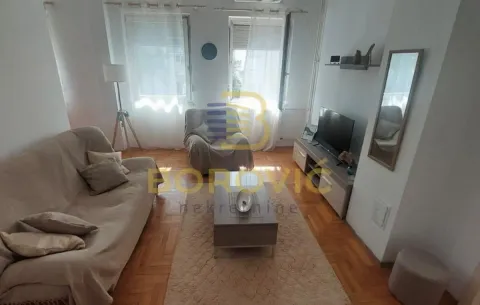 Dnevna soba sa garniturom, televizorom i drvenim podom. - image 4