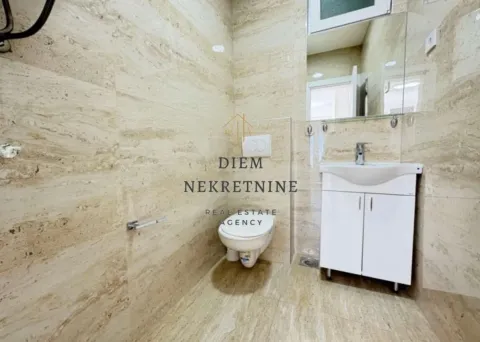 Modern tiled bathroom with a sink and toilet. - image 9