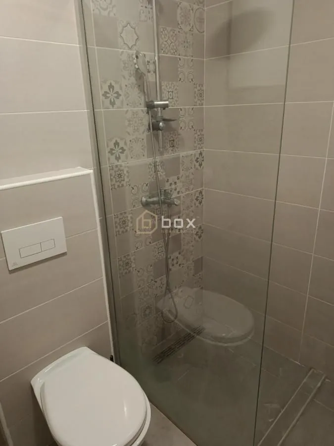 Kupatilo sa tuš kabinom i ugradnom wc šoljom.