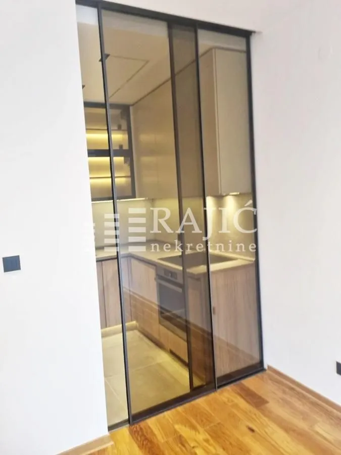 Modern kitchen behind glass sliding doors.