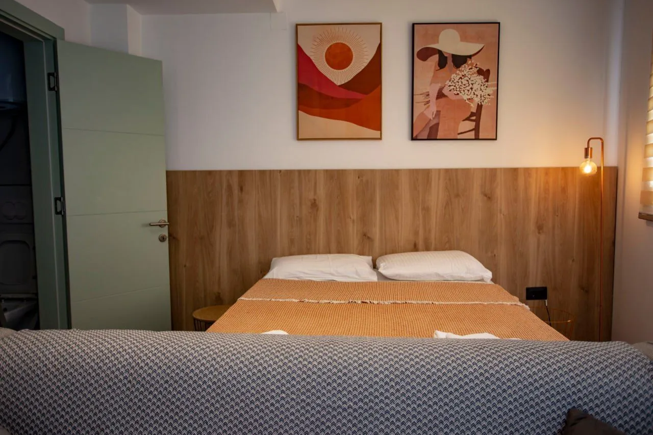Comfortable bedroom with a double bed and wooden headboard.
