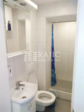 Smaller bathroom with a washbasin, toilet, and shower cabin. - image 6