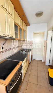 Manja kuhinja sa svetlim drvenim elementima i keramičkim pločicama na podu. - image 5