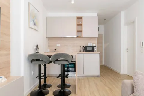 Small modern kitchen with a breakfast bar and bar stools. - image 14