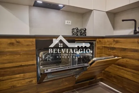 Modern kitchen with built-in oven and wood-grain cabinetry. - image 10