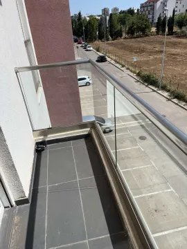 Balcony with a glass railing and street view. - image 4