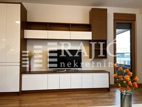 Living room with modern furniture and a TV.