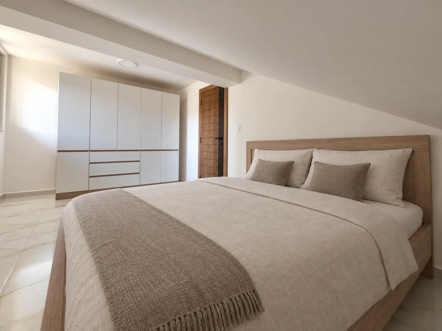 Bedroom with a double bed, white wardrobe and sloped ceiling.