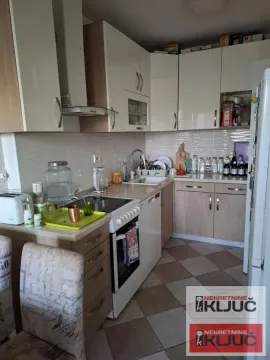 Manja kuhinja sa elementima u drvenom dezenu i belim radnim površinama. - image 8