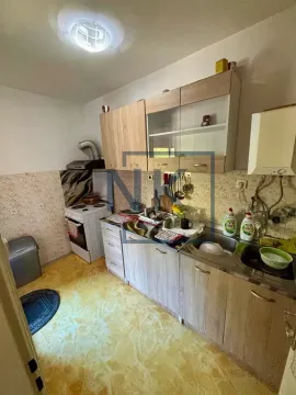 Manja kuhinja sa drvenim elementima, sudoperom i šporetom. - image 3