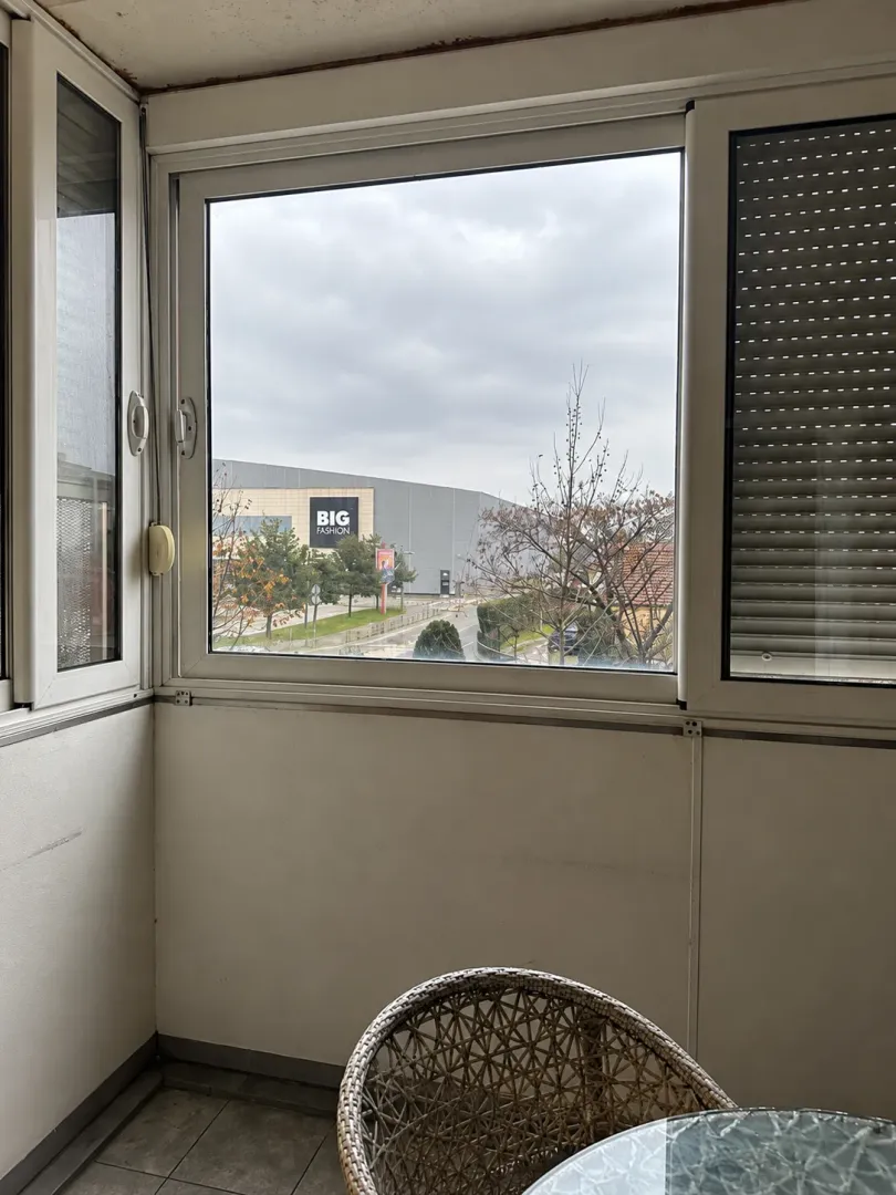 Zastakljena terasa sa pogledom na grad.