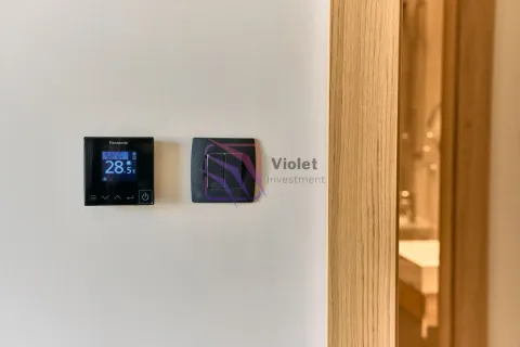 Termostat i prekidač za svjetlo na bijelom zidu pored vrata. - image 8