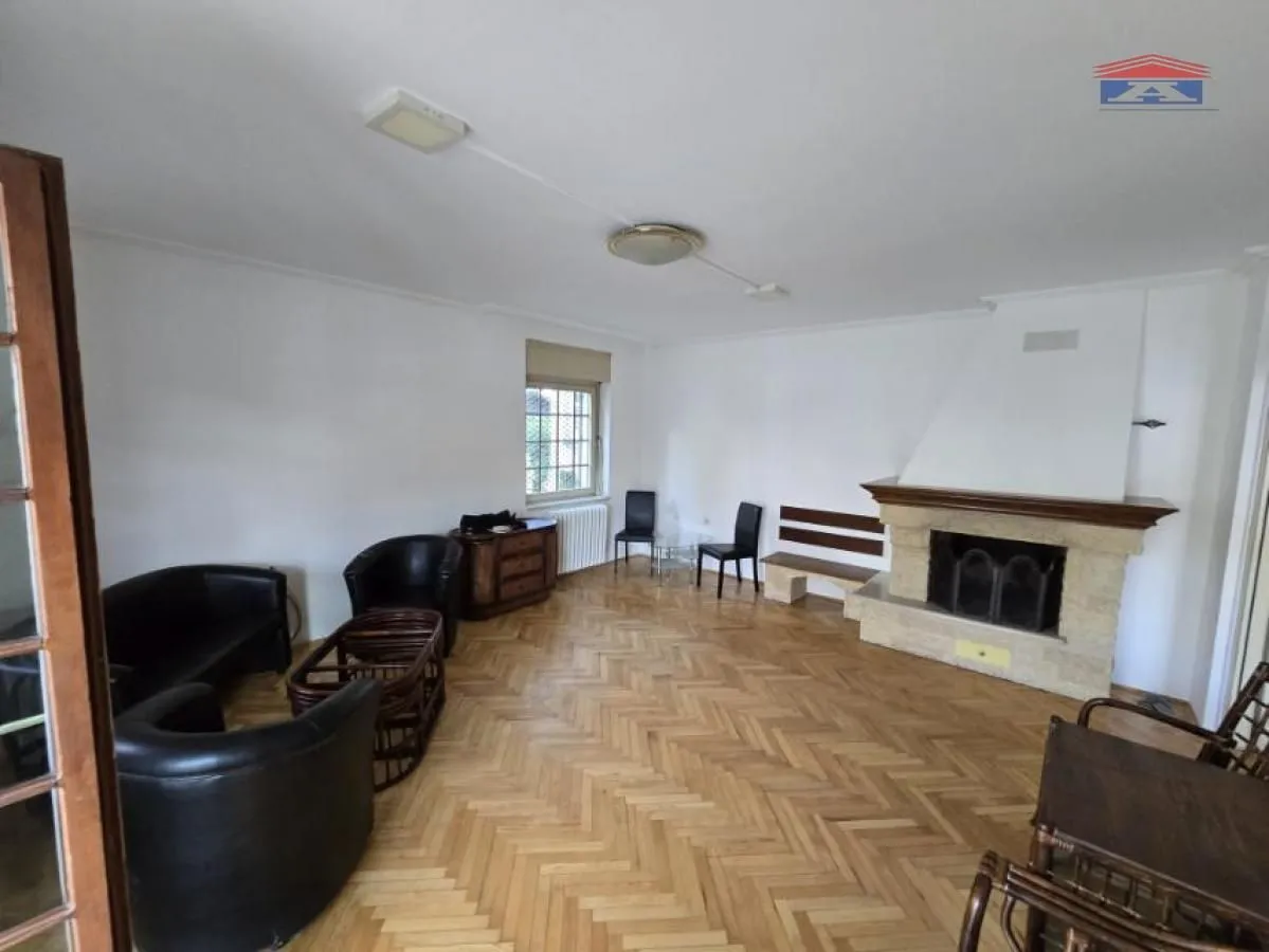 Spacious living room with a fireplace and parquet flooring.