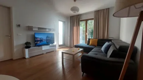 Living room with a corner sofa, television, and wooden flooring. - image 2