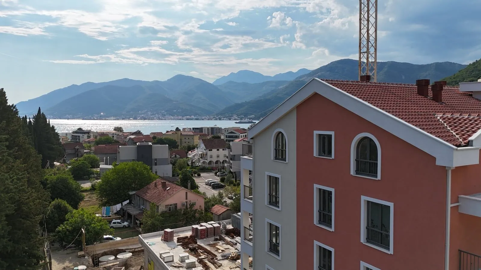 Pogled sa visine na stambenu zgradu i more u daljini.