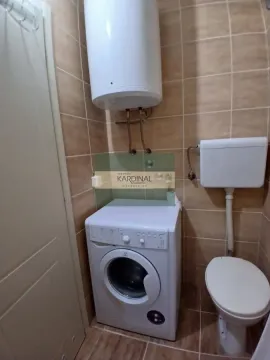 Small bathroom with a shower, washing machine, and water heater. - image 2