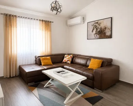Comfortable living room with a brown sectional sofa and a white coffee table. - image 12