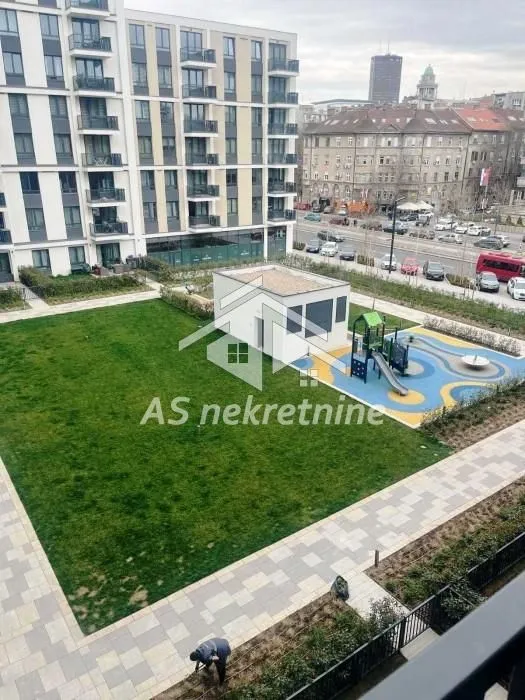 View from the building overlooking a landscaped courtyard with a lawn and playground.