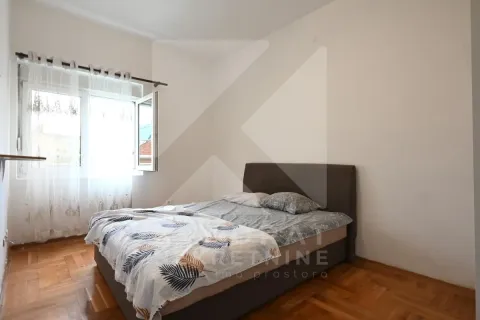 Spavaća soba sa bračnim krevetom, drvenim parketom i prozorom sa zavjesama. - image 3