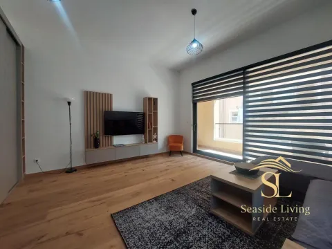 Modern living room with wooden flooring, TV unit, and access to the terrace. - image 4