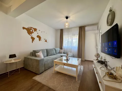 Living room with a sofa, coffee table and television. - image 3