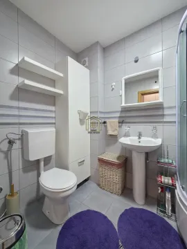 Kompaktno kupatilo sa tuš kabinom, umivaonikom, toaletom i bijelim ormarićem. - image 5